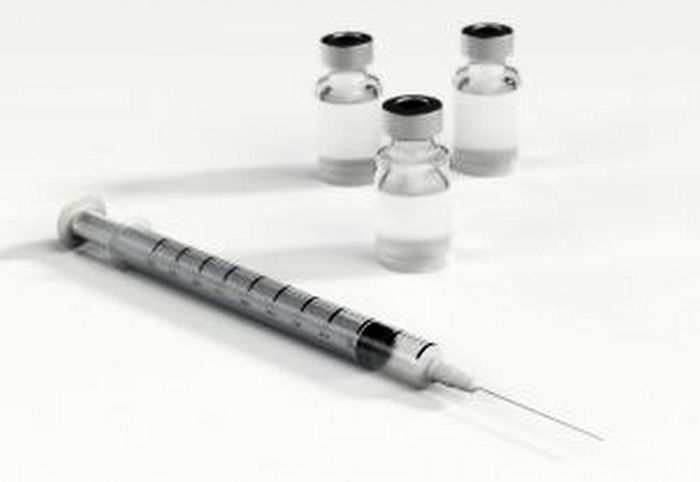 empty syringe with three glass bottles of vaccinations