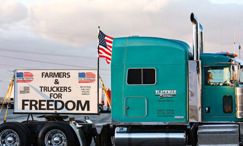 A trucker sits in his cab as truck drivers and supporters gather one day before a ‘People’s Convoy’ departs for Washington, DC, to protest COVID-19 mandates in Adelanto, California, on Feb. 22, 2022. (Mario Tama/Getty Images)