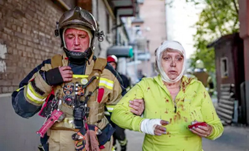 A rescuer helps an injured woman after several strikes hit the Ukrainian capital of Kyiv.